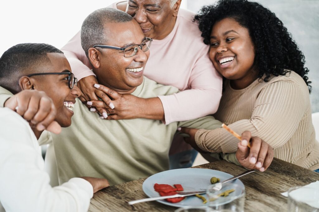 Happy black family eating lunch at home