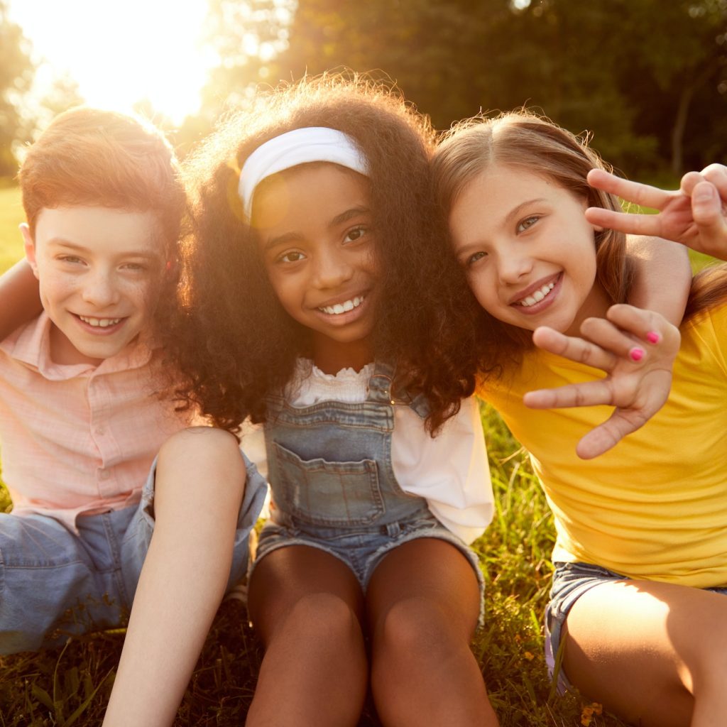 Group of multiracial kids embracing together in park